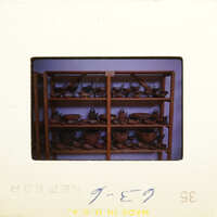 A shelf filled with various clay pots and vases.