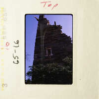 A photo of an old, weathered building with a blue sky background.