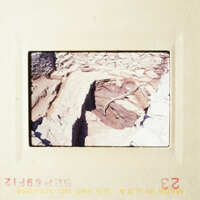 This is an old photograph showing a rocky landscape with a small cave entrance.