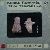 Two marble figurines displayed on a piece of paper.