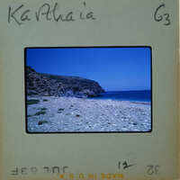 Photo of a rocky beach with the ocean and blue sky, labeled "Kathia" on an old film strip.