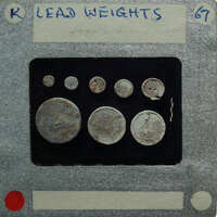 A collection of old coins displayed on a card with labels and weights.