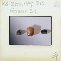 Three beads on a white surface with writing and numbers around them.