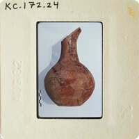 Old clay pot with cracks and worn surface, displayed on white background.