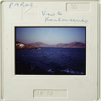 Ocean view with mountains and shoreline, captured on an old photograph.