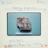 A small, damaged wooden object on a white background with measurements and labels.