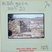 Old photograph of a stone wall with mountains in the background, marked as "MBA GATE WALL" and labeled with numbers.