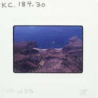 Aerial photograph of a coastal landscape with islands and mountains.