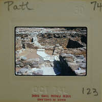 A photograph of an ancient stone structure with a dirt floor, possibly ruins.