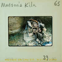 Old rusted metal objects piled on a rock surface.