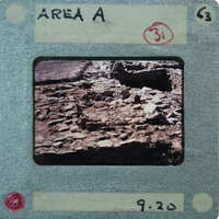 A photograph of an archaeological site with ruins and rubble, enclosed within a film strip frame.