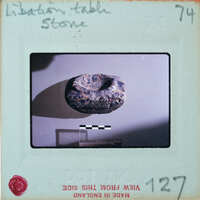 Very small stone with circular indentation at the top.