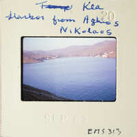 The image shows a scenic view of a harbor with mountains and water, captured on an old slide film.