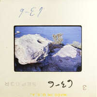 Rocky shoreline with water in the background.