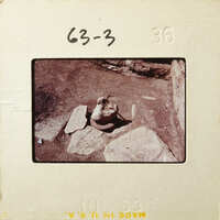 Old photograph of an archaeological site with rock formations and artifacts.