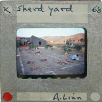 A vslide of people working on a field drying sherds.