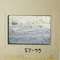 The photo shows an ancient Greek city with ruins and stone structures, captured through a vintage film strip.