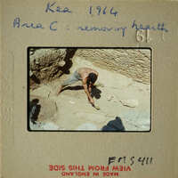 Man working on stone structure with tools.