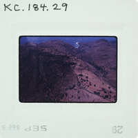 An old photograph of a mountainous landscape with a river, displayed on a film strip.