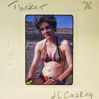 Woman wearing a colorful swimsuit in an old photo.