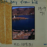 A vintage photograph of a scenic landscape with mountains, water, and ruins, featuring an old-fashioned camera negative strip.