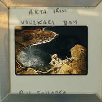 Picture of a lake with mountains in the background, framed and displayed on a table.