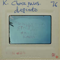 A Polaroid photo with a handwritten message in Greek, displayed on a white card with blue writing and numbers.