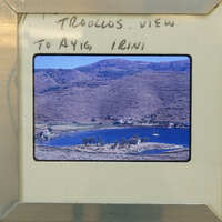 Picture of a scenic landscape with mountains, water, and houses.