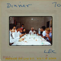 A group of people sitting around a table, eating dinner together.