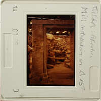 The image shows an ancient underground chamber with stone walls and columns, likely part of an archaeological site.