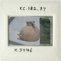 A photograph of an antique clay pot with visible cracks and imperfections.