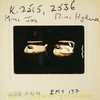 Two miniature jars with lids, displayed on a surface.