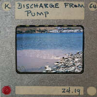 Picture of a body of water with brown sediment, possibly from a pump discharge, captured on an old film strip.