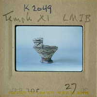 Ancient ceramic bowl with intricate designs on a white background.