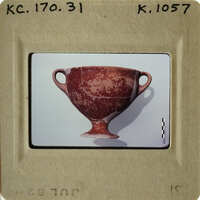 Ancient ceramic cup with handle and base, displayed against white background.