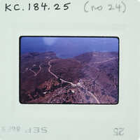 Aerial photograph of a coastal landscape with roads and vegetation.