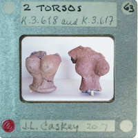 Two ancient clay figurines on display.