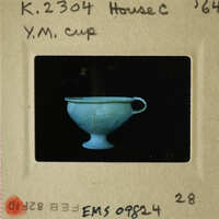 Blue ceramic cup with handle on black background.