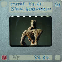 Detail of almost complete terracotta figurine torso from the back minus right arm.