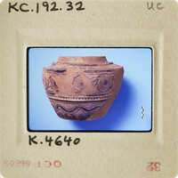 Ancient ceramic pot with intricate designs on display.