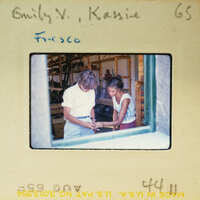 Two people looking at a piece of paper together.