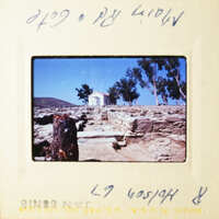 A vintage photo of an outdoor scene with a church and trees, taken from a low angle.