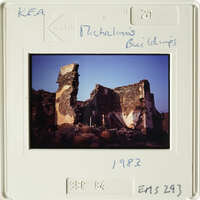 Old photograph of destroyed building with visible damage and rubble, taken in 1982.