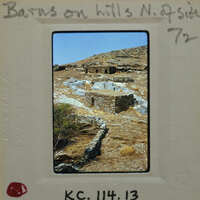 Old photograph of stone ruins on a hillside with handwritten notes.