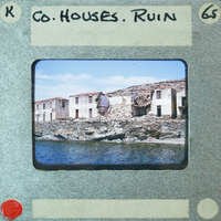 Old photograph of a destroyed building by the water.