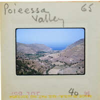 A slide of a scenic valley with mountains and a body of water.