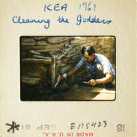 Man working on stone structure with chisel and mallet.