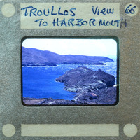 A vintage film strip showing a coastal landscape with mountains and water.