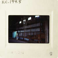A photograph of an empty room with many shelves and boxes, taken from a low angle.