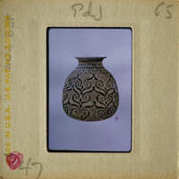 An antique vase with intricate designs on display.